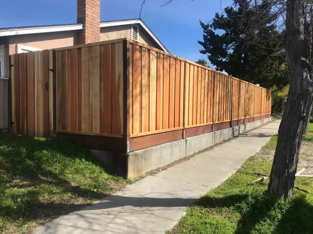 Wood fence on a concrete retaining stem by Meza's Fence